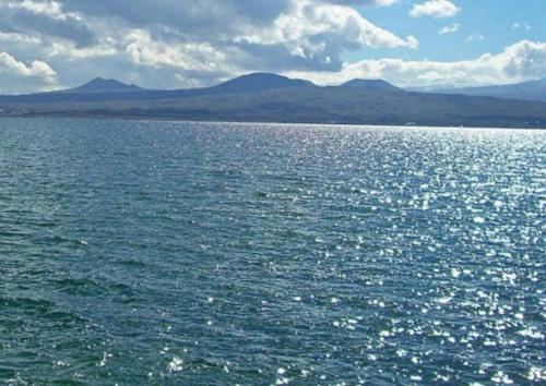 un grande bacino d'acqua con montagne sullo sfondo di Nina BNB a Sevan