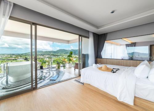 a bedroom with a bed and a tub and a balcony at The Blue Hotel - SHA Plus in Chalong 