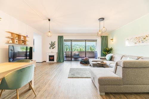 un soggiorno con divano e tavolo di Fabulous Panorama Silver Mountain Apartments a Poiana Brasov