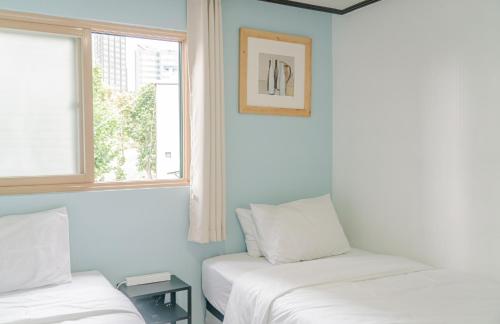 two beds in a room with two windows at For family group, 4min to Seoul station in Seoul