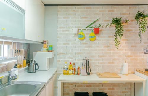 a kitchen with a sink and a brick wall at 4min to Seoul station 3R 2Bath in Seoul