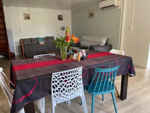a dining room table with blue chairs and a couch at ti Kaz Papang in La Plaine des Cafres