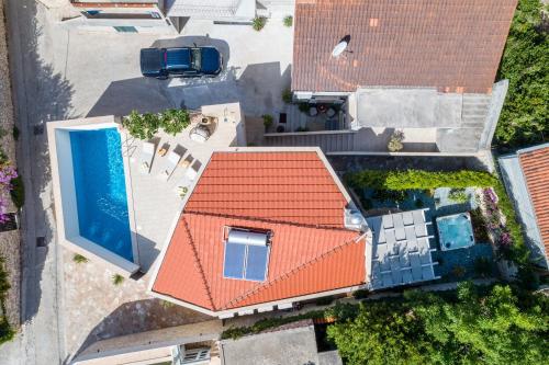 uma vista sobre uma casa com um telhado laranja e uma piscina em Villa Stone Pearl em Sutivan