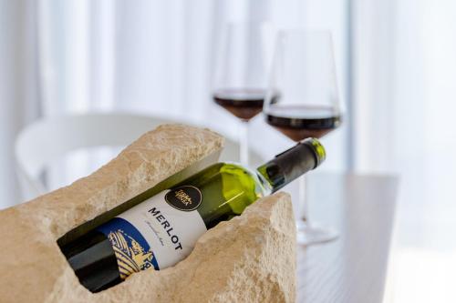 a bottle of wine and two glasses of wine at Villa Stone Pearl in Sutivan
