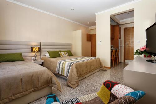 a bedroom with two beds and a flat screen tv at Oporto City Centre Apartments in Porto