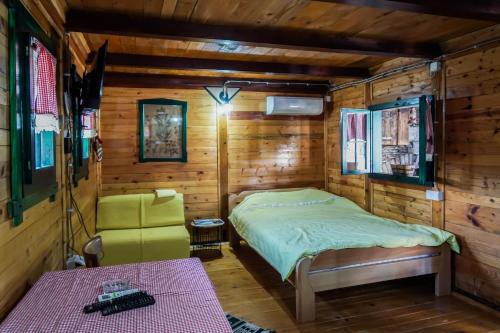 ein Schlafzimmer mit einem Bett in einer Holzhütte in der Unterkunft Vajat BB in Bajina Bašta