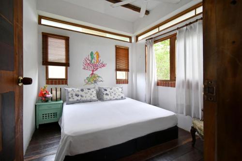 a bedroom with a white bed and a window at Casa Caracola in Tubará