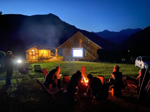 a group of people sitting around a fire at night at Mountain House Chirdili in Chirdili