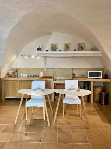 - deux tables et des chaises dans une cuisine avec une arche dans l'établissement B&B Villa des Muses, à La Roque-dʼAnthéron