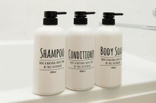 a group of four shampoo bottles on a shelf at Villa Roppongi in Tokyo