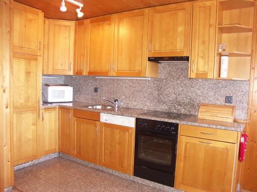 アンゼールにあるApartment Mars 502のキッチン(木製キャビネット、シンク、コンロ付)