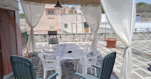 OLTREMARE casa per vacanze con terrazzo في كازارانو: طاولة بيضاء وكراسي على الفناء