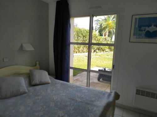 um quarto com uma cama e uma porta para um pátio em Garden level with sea view for 6 people em Saint-Raphaël