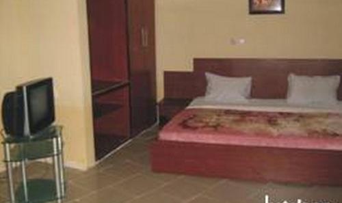 a bedroom with a bed and a flat screen tv at Ade Super Hotel Single in Akure