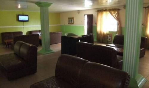 a waiting room with couches and chairs and columns at Ade Super Hotel Single in Akure