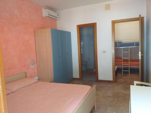 a bedroom with a bed and a cabinet and a mirror at Quadruple room in Pineto - Just a few meters from the sea in Pineto