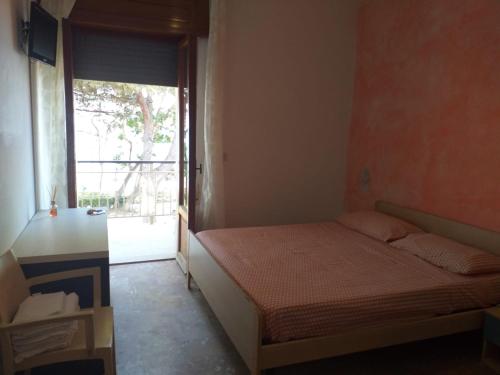 una piccola camera con letto e finestra di Room in BB - Quadruple room in Pineto - Enjoy a relaxing holiday a Pineto