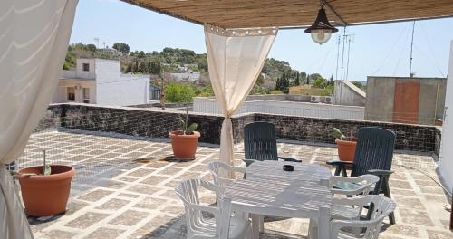 un patio con mesa y sillas en la azotea en OLTREMARE casa per vacanze con terrazzo en Casarano
