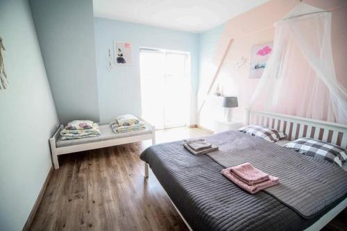a bedroom with a bed and a crib with two babies at Sweet Nest Apartment in Giżycko