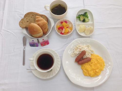 a table with plates of food and a cup of coffee at Hotel Koshien in Nishinomiya