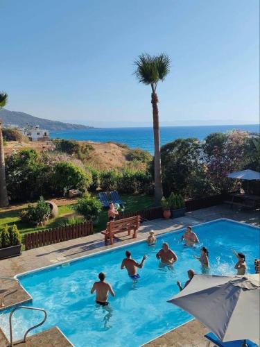 a group of people playing in a swimming pool at Kanalli Apartments in Pomos