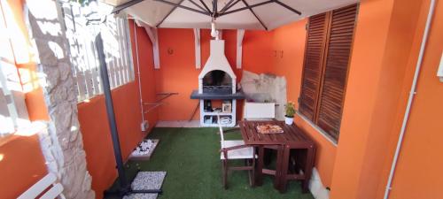 Camera arancione con tavolo e piano cottura di I love Ogliastra Apartments a Bari Sardo