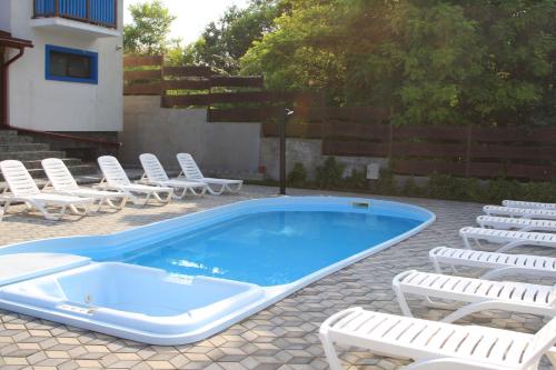 a swimming pool with chairs and a bunch ofitures at Camere de inchiriat Baltenii de Sus in Băltenii de Sus