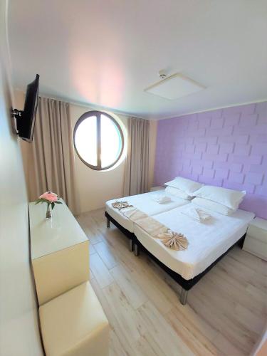 a bedroom with a large bed and a window at Camere de inchiriat Baltenii de Sus in Băltenii de Sus