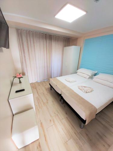 a bedroom with a large bed and a television at Camere de inchiriat Baltenii de Sus in Băltenii de Sus