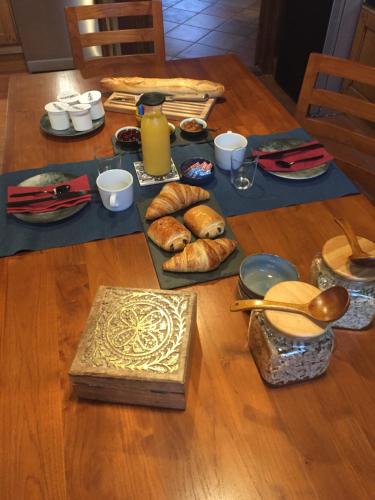 - une table avec des croissants, du pain et une bouteille de jus d'orange dans l'établissement La Prévôté, à Marchenoir