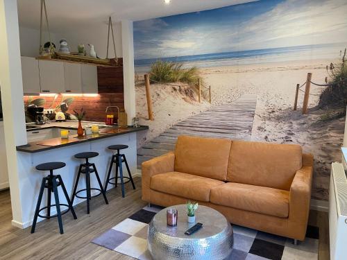 a living room with a couch and a beach mural at FeWo & Dz "Am Wald" in Altheide