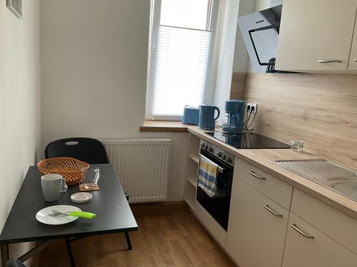 een kleine keuken met een tafel en een fornuis top oven bij Ferienwohnung Spremberg-City I in Spremberg