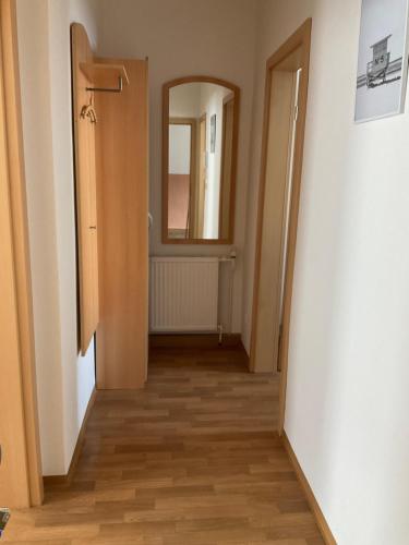 a hallway with a door and a mirror at Ferienwohnung Spremberg-City I in Spremberg