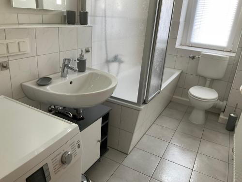 een witte badkamer met een wastafel en een toilet bij Ferienwohnung Spremberg-City I in Spremberg