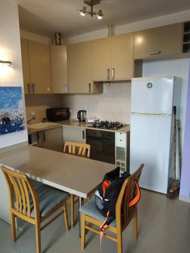 a kitchen with a table and chairs and a refrigerator at Marshov Rehovot - Apartment in center of Rehovot near shopping mall and Weizmann Institute in Rechovot