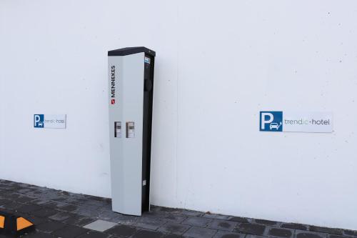 a white wall with a parking meter next to it at Trendic Hotel in Marktoberdorf