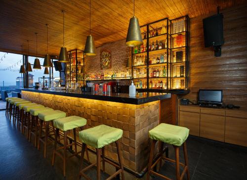 a bar with a barber shop and several tables at Hotel Ambassador by ACE Hotels in Kathmandu