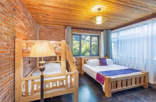 懷柔的住宿－Beijing Mutianyu Great Wall Wangshanyuan Homestay，一间卧室配有两张双层床和一盏灯。