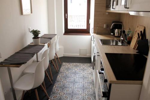 - une cuisine avec un comptoir, un évier et des chaises dans l'établissement Nod off in Neudorf! Cozy 2 beds near the tram, à Strasbourg