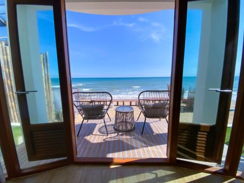 a view of the ocean from the balcony of a house at Maldives Beach Resort in Chao Lao Beach