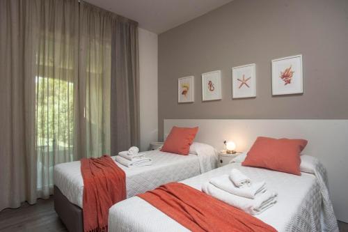 a bedroom with two beds with towels on them at Villa Elegance Sabrina in SantʼAnna Arresi