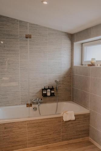 a bathroom with a bath tub and a window at Jeanne in Nieuwpoort