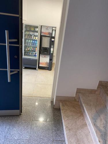 an empty room with an open refrigerator and stairs at Garni San Paolo in Appiano sulla Strada del Vino