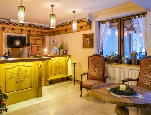 a kitchen with a table and chairs and a counter at Willa Ryś in Zakopane