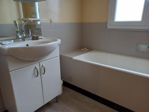 une salle de bain avec un lavabo et une baignoire dans l'établissement Appartement Grande terrasse à 1min de la plage, à Saint-Palais-sur-Mer