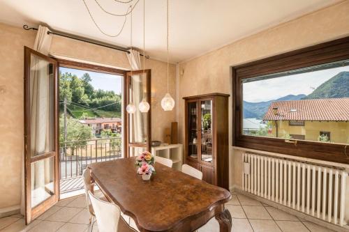 a dining room with a table and a large window at Appartamento vista lago in Sulzano