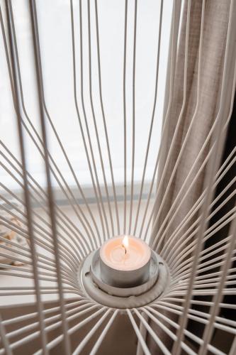 a candle in a room with a window at Jeanne in Nieuwpoort