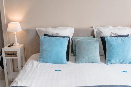a bed with blue and white pillows on it at Jeanne in Nieuwpoort
