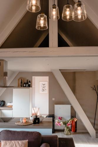 a living room with exposed ceilings and lights at Jeanne in Nieuwpoort