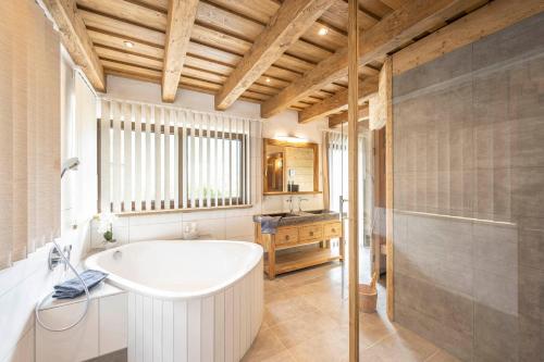 a bathroom with a white tub and a sink at Almdorf Auszeit Fageralm in Forstau